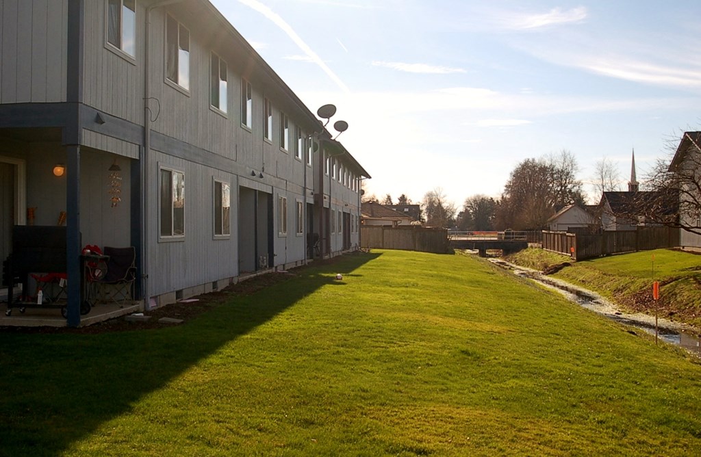 a view of the side of a building with a grassy yard