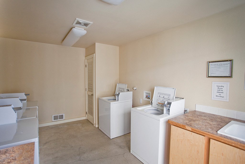 a laundry room with two washers and two washing machines