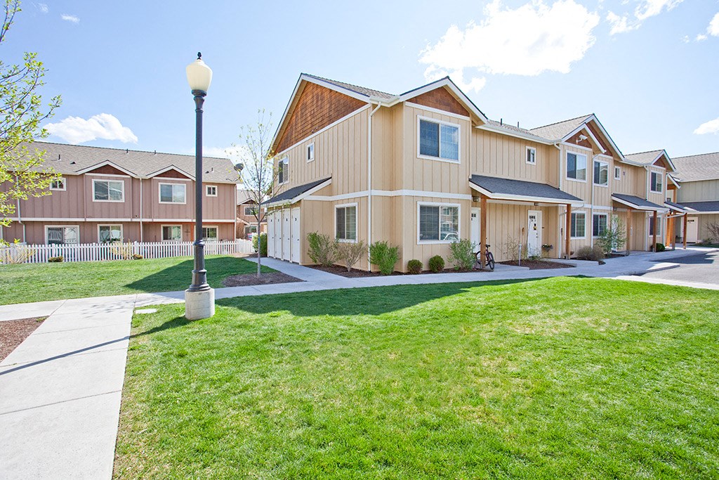 a row of homes with a lawn and sidewalk