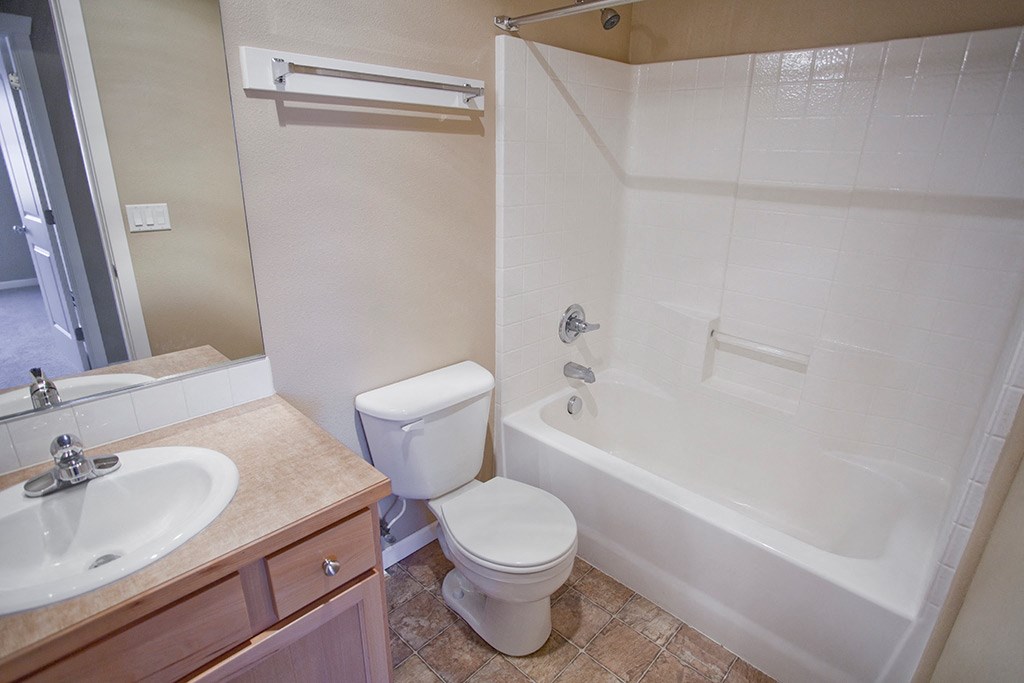 a bathroom with a toilet and a tub and a sink