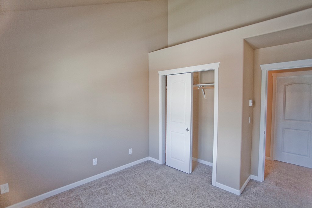 a bedroom with a closet and a door to a hallway