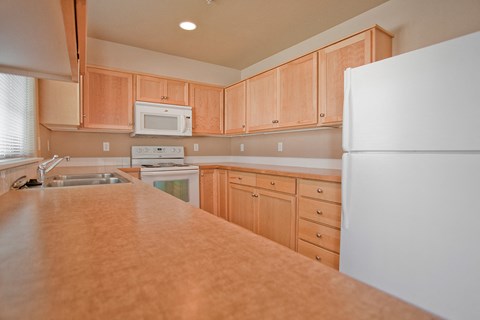 a kitchen with wooden cabinets and appliances and a counter top