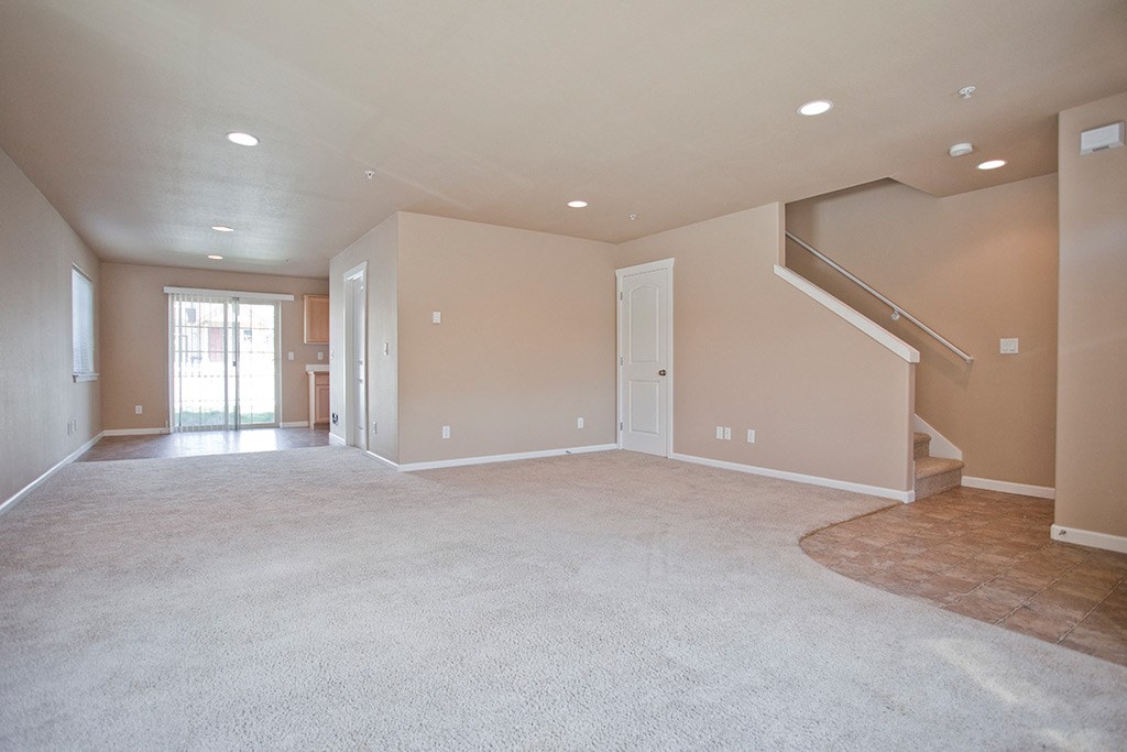 the spacious living room and entryway of a new home