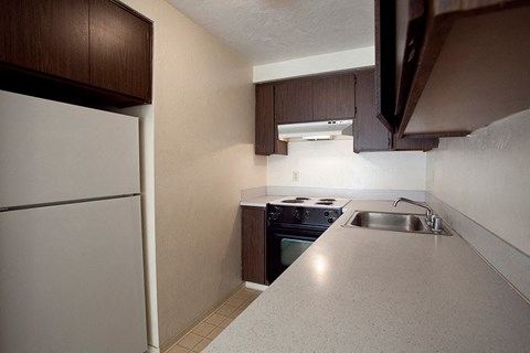 A kitchen with a white fridge and a stove top oven.