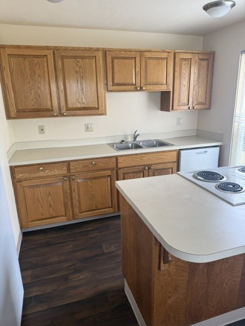 A kitchen with wooden cabinets and a white counter.