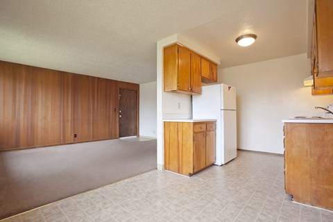 A kitchen with white appliances and wooden cabinets.