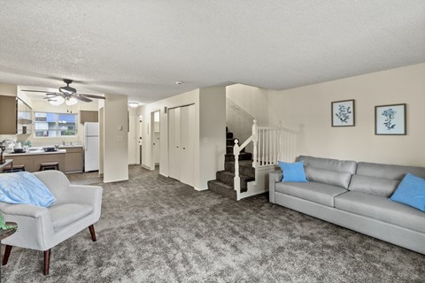 A living room with a grey couch and a grey armchair.