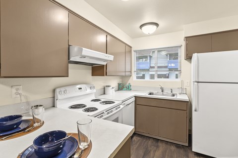 A kitchen with brown cabinets and white appliances.