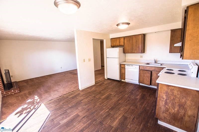 an empty kitchen with a stove and a refrigerator