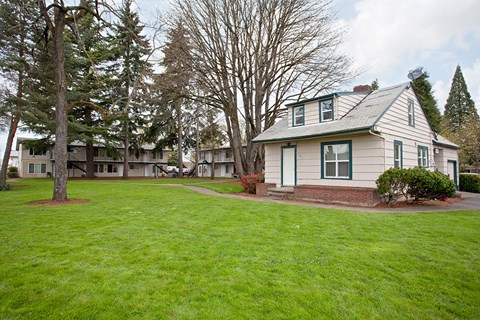 A house with a green lawn in front of it.