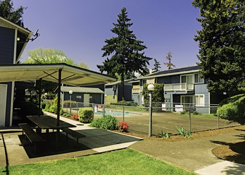 a picnic table in a park next to a tennis court