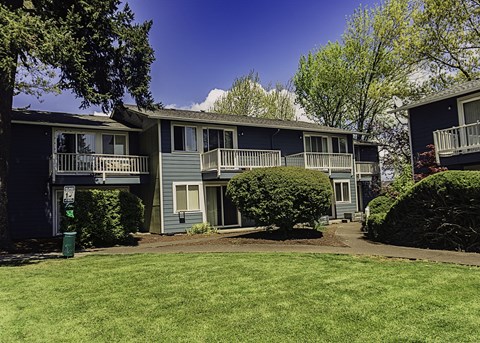 an apartment building with green grass and trees