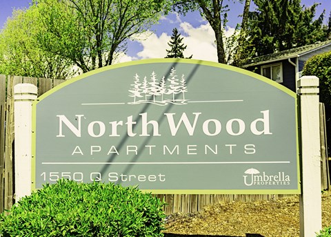 a sign for northwood apartments in front of a house