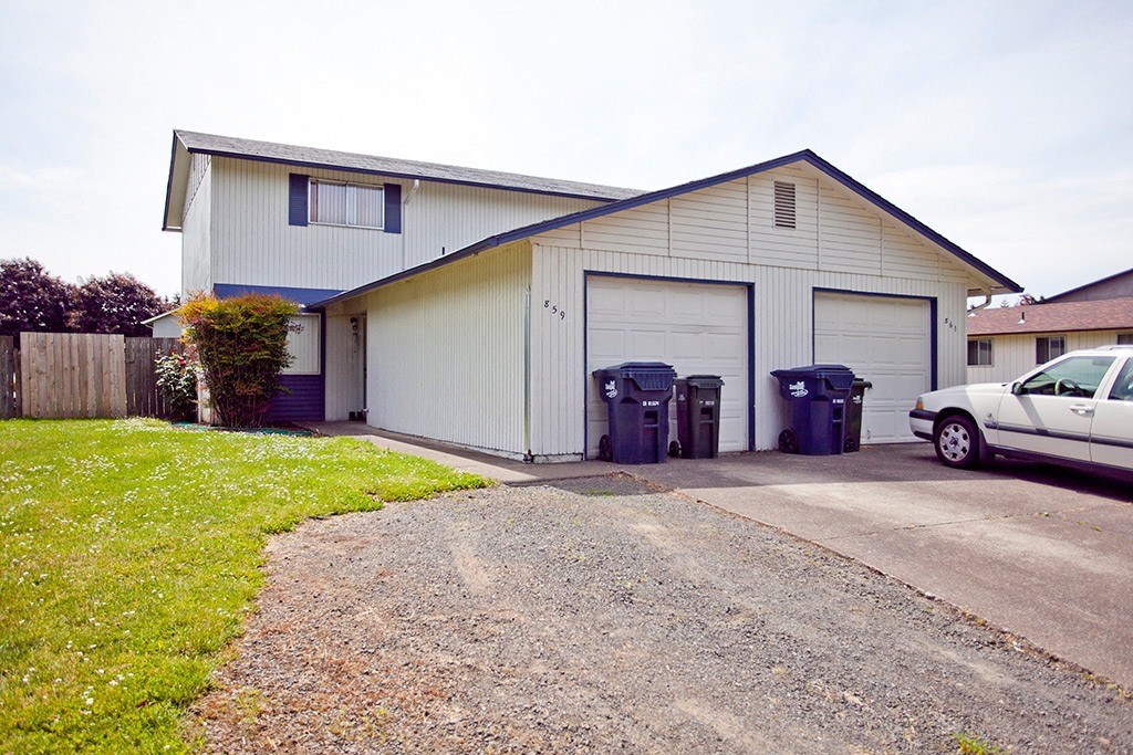 a white house with a car parked in the driveway