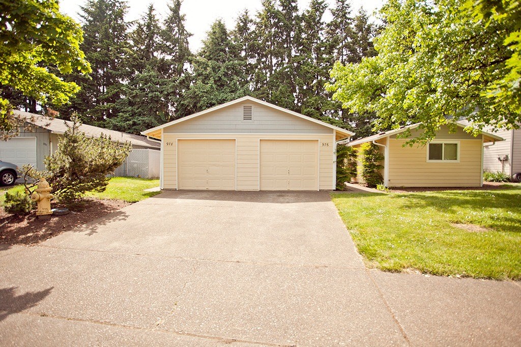 a white garage with a driveway in front of a house