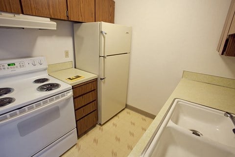 a kitchen with a stove refrigerator and sink