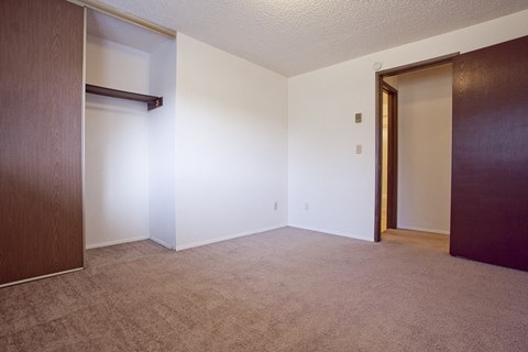 an empty living room with a door to a closet