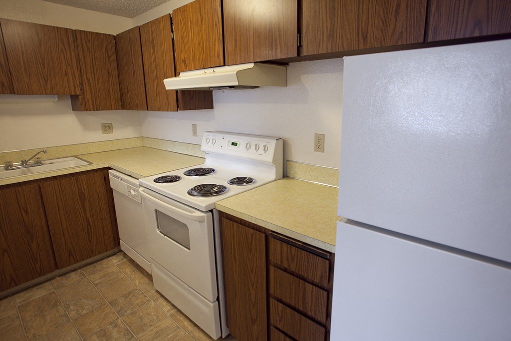 a kitchen with white appliances and wooden cabinets
