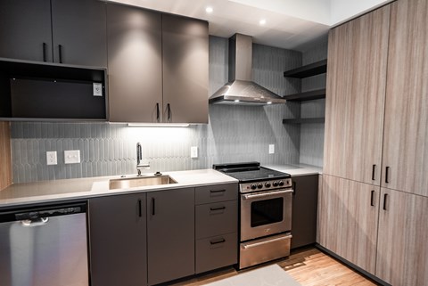 A modern kitchen with dark brown cabinets and stainless steel appliances.