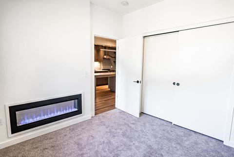 A modern room with a fireplace and a carpeted floor.