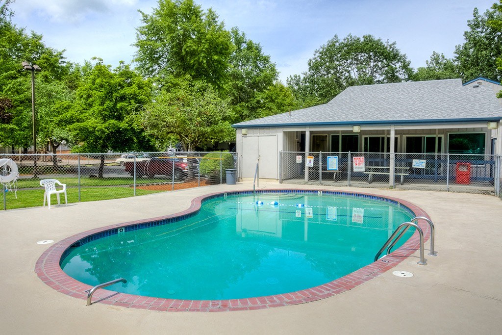 a resort style pool with a house in the background