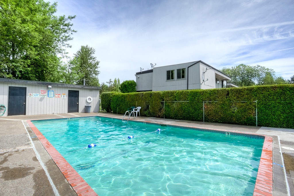 a swimming pool with a house in the background