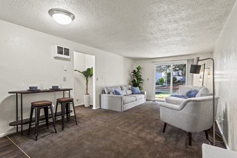 A living room with a grey couch and a brown table.