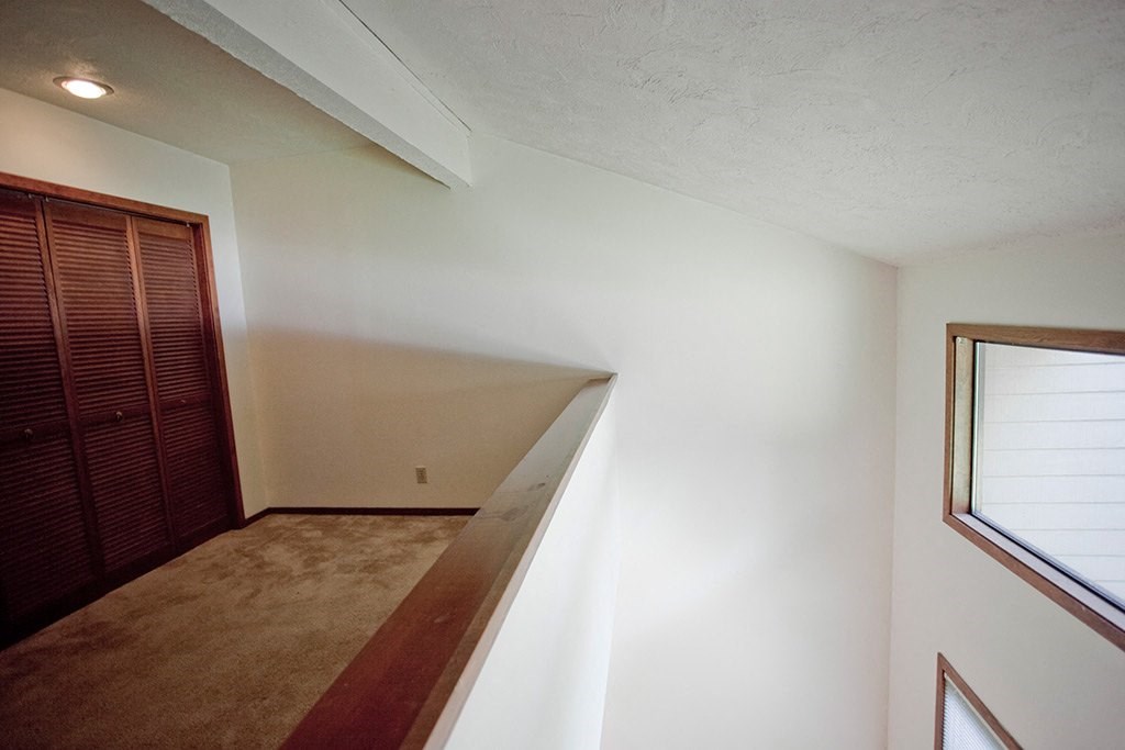 a room with a staircase and a window and a wooden closet