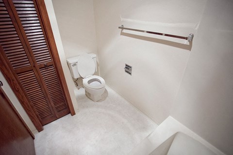 a small bathroom with a toilet and a wooden door