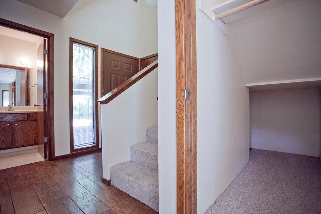 the entryway to a house with stairs and a door to a bathroom