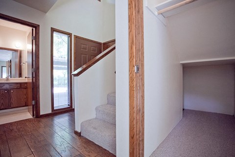 the entryway to a house with stairs and a door to a bathroom