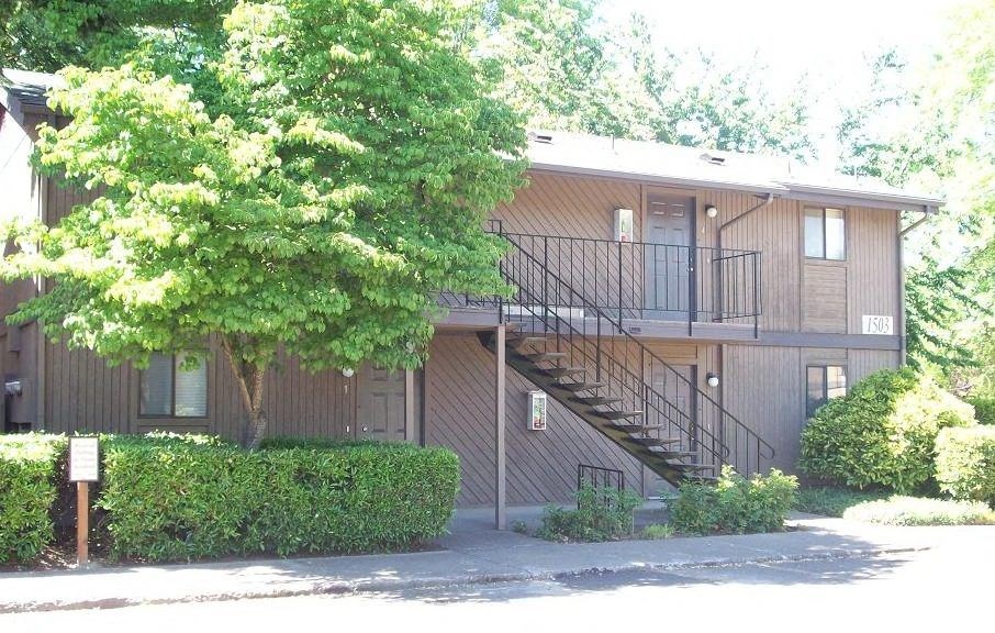 an apartment building with a tree in front of it