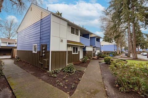 A small building with a brown door and a blue wall.