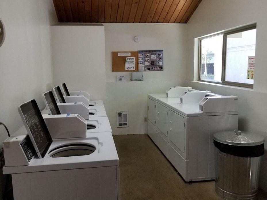 an empty laundry room with two washers and a sink