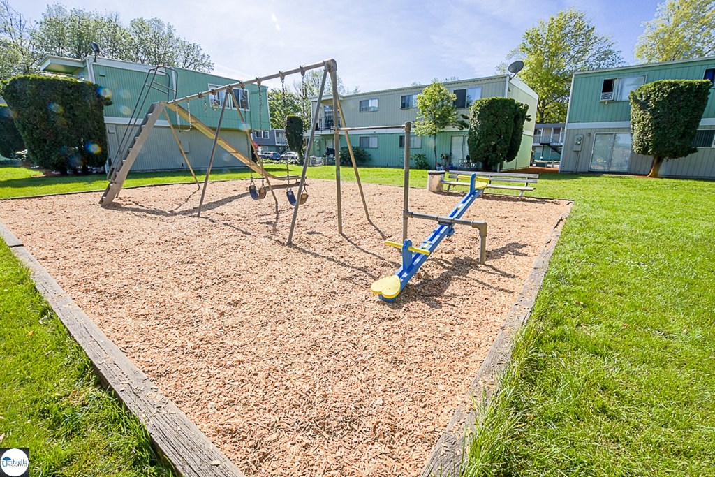 a playground with a swing set in a park