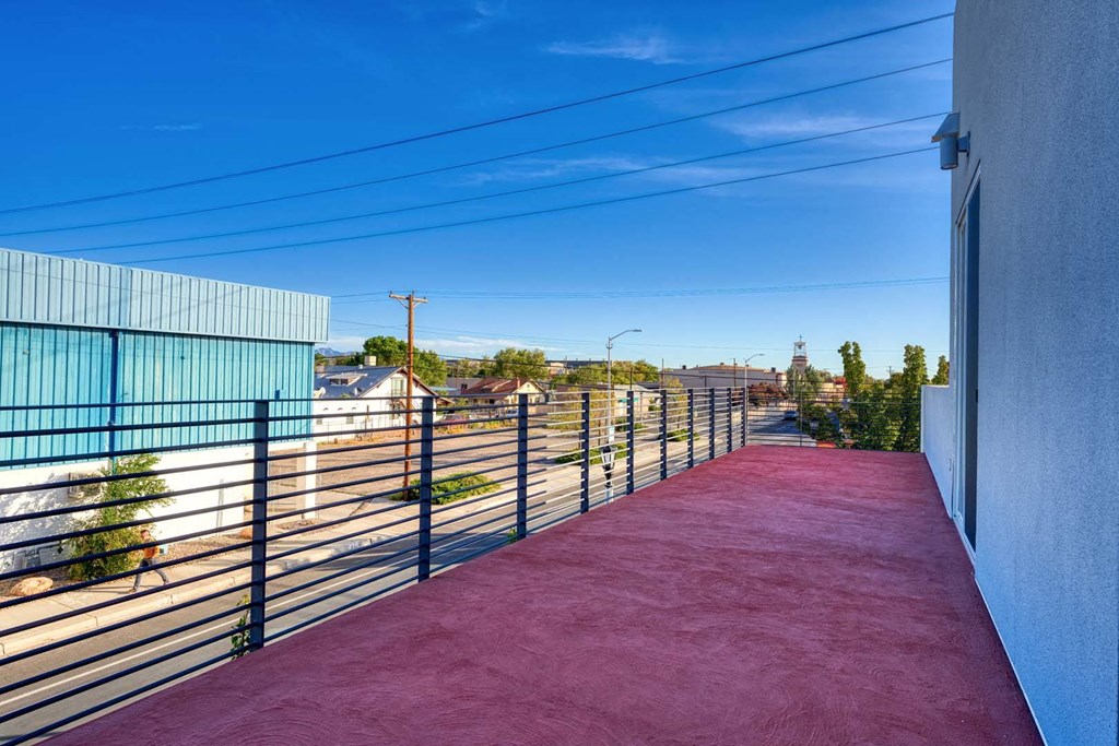 a red walkway leading to a building with a metal fence