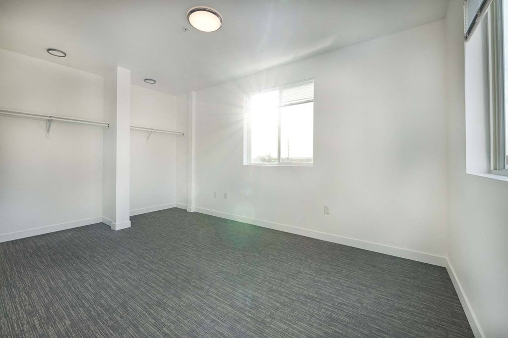 an empty room with white walls and a window