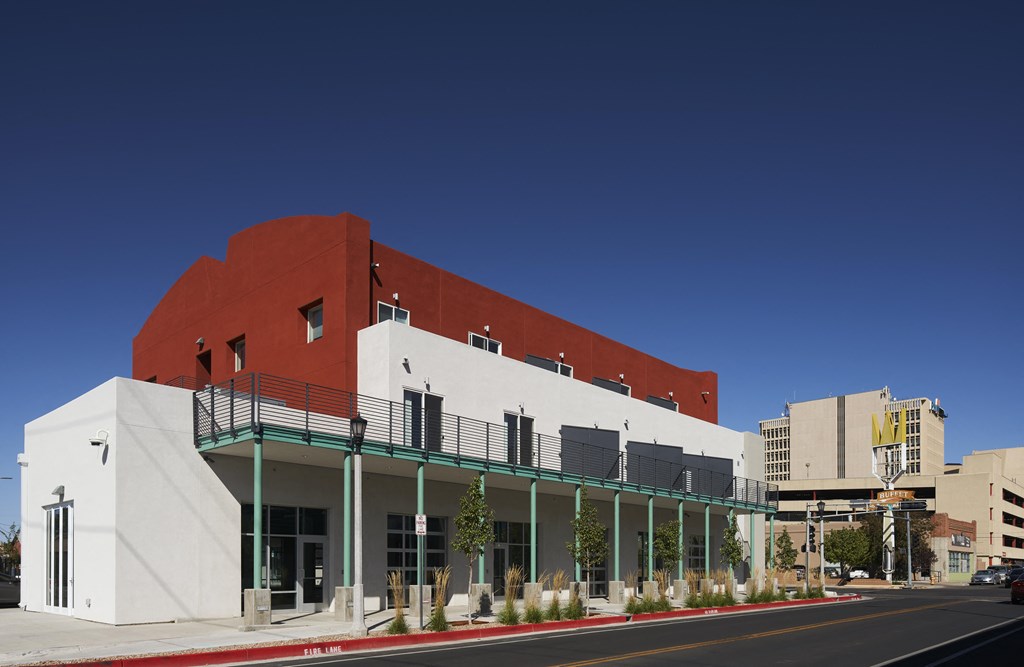 a white and red building with a balcony on a city street