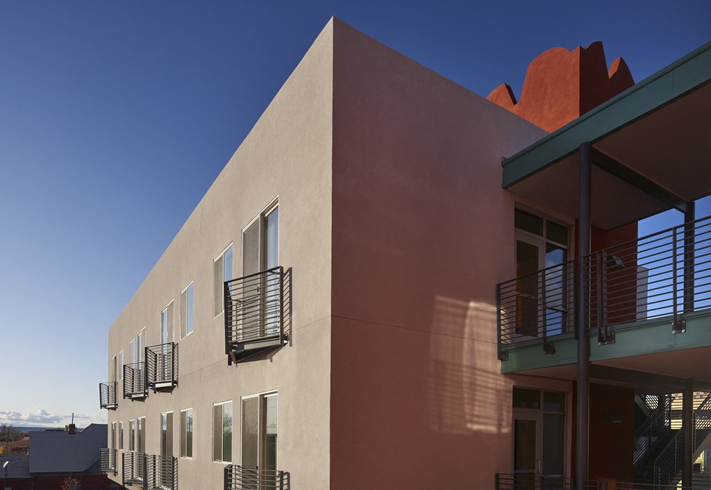 the side of a building with balconies and a blue sky