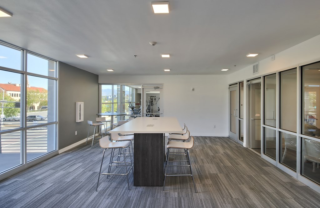 a conference room with a white table and chairs and large windows