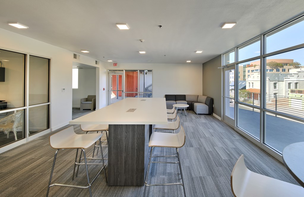 a room with a table and chairs and a large window