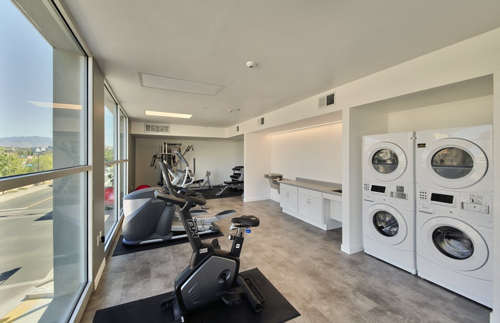 a washer and dryer in a laundry room with a window and washing machines