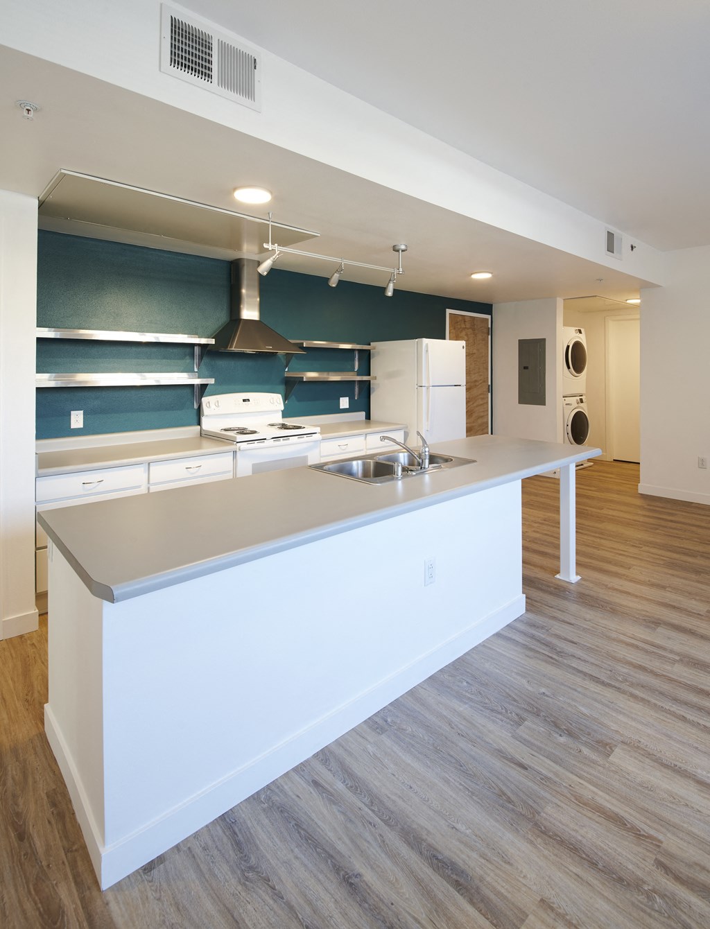 a kitchen with a large island and a stove and a refrigerator