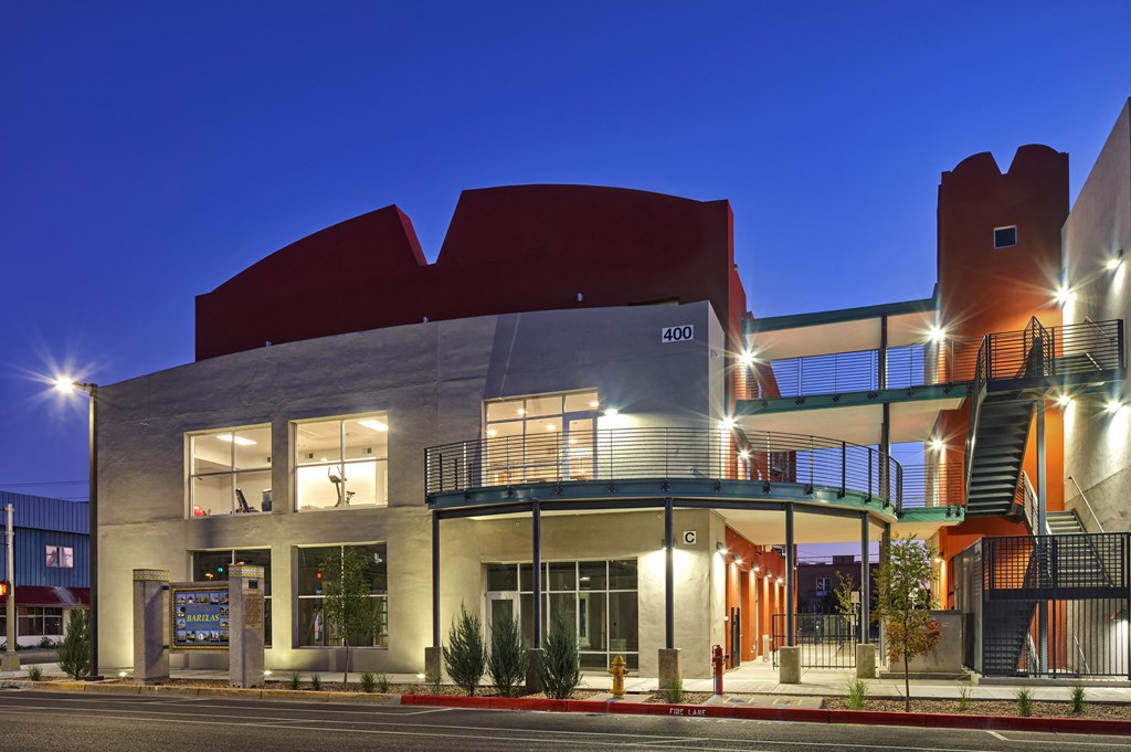 a modern building with a street in front of it at night