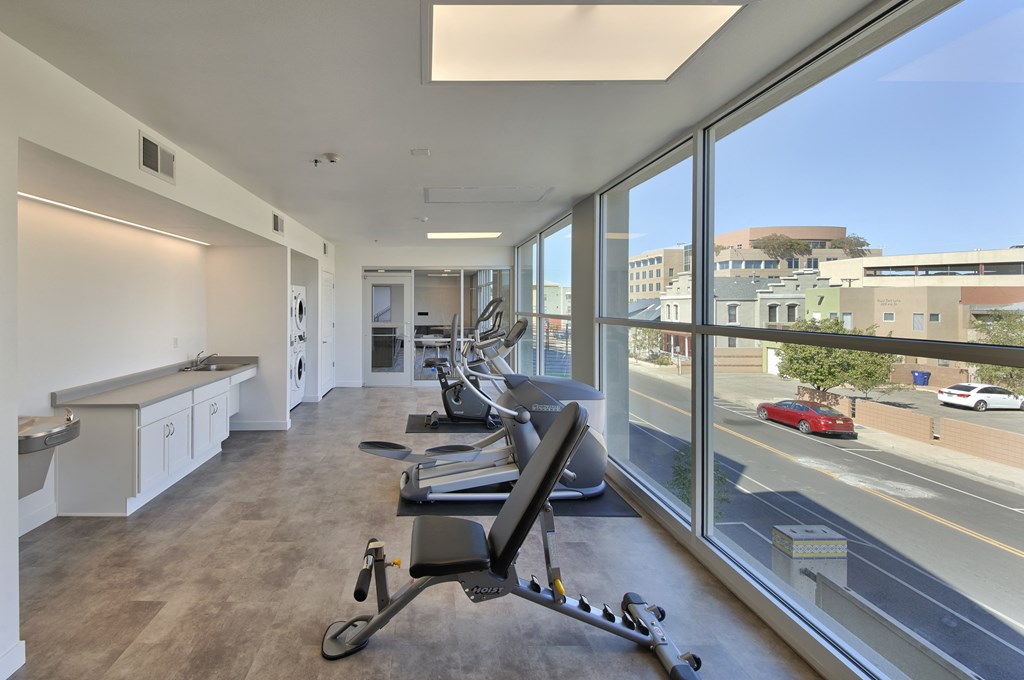 a gym with desks and chairs in front of a large window