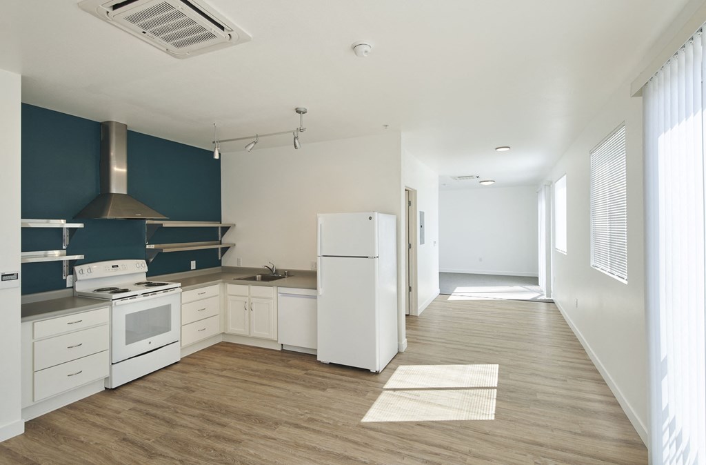 an empty kitchen with white appliances and blue and white walls