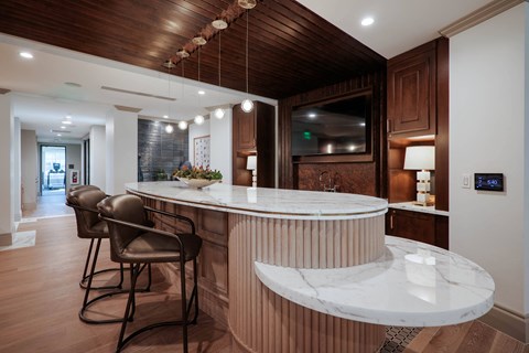 A modern kitchen with a bar area and a television.