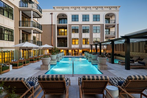 A large building with a pool in front of it.