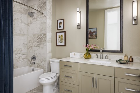 A bathroom with a marble wall and a white toilet.
