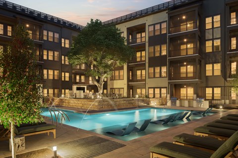 A large building with a pool in front of it.